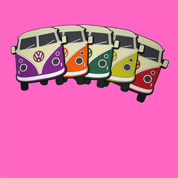 Five PVC rubber coasters moulded in the shape of the front of a Volkswagen Camper Van on a pink background. Each coaster is a combination of cream and one other colour; purple, orange, green, yellow and red.