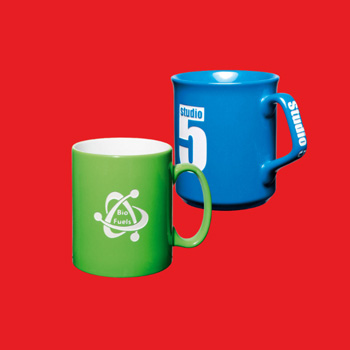 Two etched mugs on a red background. One mug is bright green and the other bright blue. Both have an etched design, in white, on the outer body of the mug