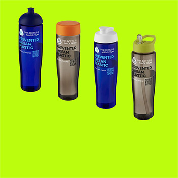 Four H2O Active sports bottles on a lime green background. Two bottles have a see-thru blue coloured bottle body whilst two have a see-thru charcoal coloured body. Each has a different type of lid: blue dome lid, orange screw on cap, white flip lid and lime green spout lid.